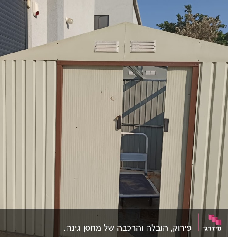 מחסן מתכת פתוח עם עגלת עבודה בפנים
